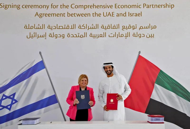 以色列经济部长Orna Barbivai和阿联酋经济部长Abdulla bin Touq Al Marri在自由贸易协议签字仪式上合影 ...